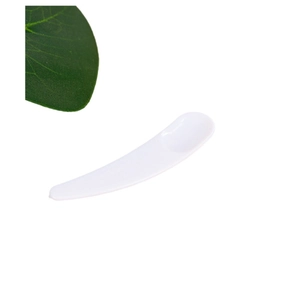 White plastic cosmetic facial cream scoop spatula with a green leaf on white background