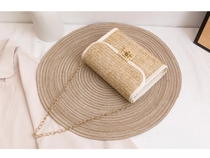 Detail of straw crossbody bag with leather trim, gold twist lock and metal chain strap