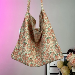 Detailed close-up of corduroy shoulder bag featuring vintage pink floral patterns