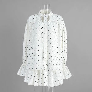 Detailed view of the pussy-bow neckline and ruffled cuffs on the polka dot shirt set