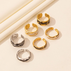 Set di 6 anelli aperti oro e argento con smalto nero e bianco su morbido tessuto beige