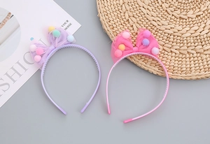 Detail of pink and purple mesh bow headbands with colorful fuzzy balls for girls