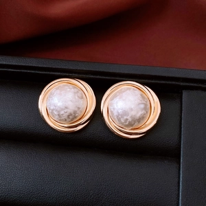 Detailed macro view of vintage gold plated earrings with white textured cotton beads
