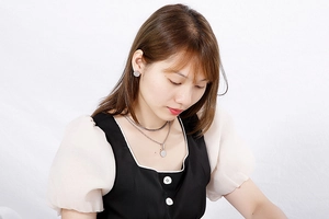Close-up of model wearing double-layer silver titanium steel necklace and round stud earrings