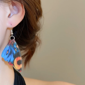 Detailed close-up of vibrant acrylic butterfly wing earrings with colorful patterns