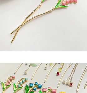 Detail of vintage gold metal hairpins with enamel flowers and elegant pearl tassels