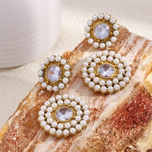 Detailed close-up of 18K gold plated earrings with white pearls and clear crystals