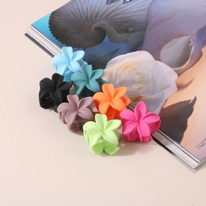 Matte flower hair claws set in seven candy colors displayed on a beige background