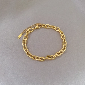 Detailed macro view of the gold stainless steel chain link bracelet with lobster clasp