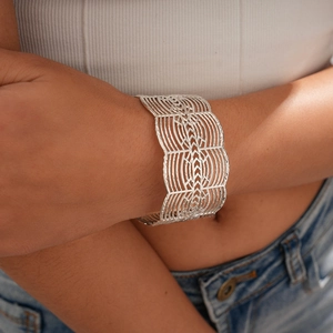 Detail shot of wide hollow silver cuff bracelet with intricate geometric patterns