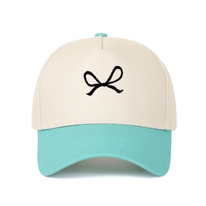 Two-tone cotton baseball cap with cream crown, blue brim and embroidered black bow