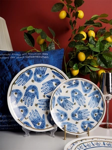 Detail of Hamsa Hand pattern with gold rim on ceramic plates for home decoration