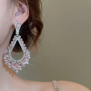 Gros plan d'élégantes boucles d'oreilles nœud avec cristaux roses et diamants argentés