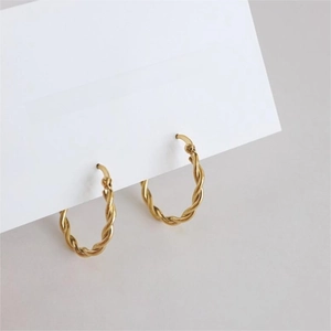 Close-up of golden 925 sterling silver twisted hoop earrings with textured finish
