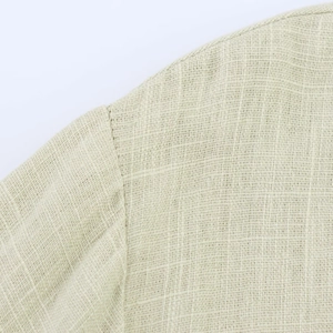 Detailed macro shot of the linen dress fabric texture and professional shoulder seam sewing