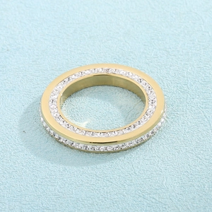 Détail macro d'une bague en acier doré sertie de deux rangées de cristaux étincelants