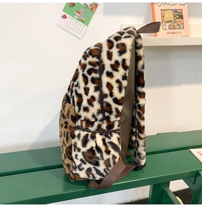 Vista laterale di uno zaino in peluche con stampa leopardata su una panca con dettagli