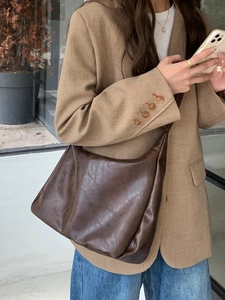 Close-up of vintage dark brown faux leather shoulder bag with stitching and soft texture