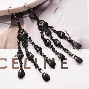 Detail of Gothic style drop earrings with black crystals and rhinestone tassels