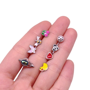 Macro shot of colorful fruit and animal enamel body piercing jewelry held in hand