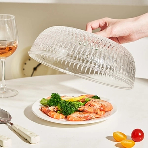 Transparente Speiseglocke aus Glas mit Rautenmuster auf einem Teller mit Garnelen