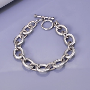 Detail of chunky oval chain link bracelet with spiral texture and silver-tone toggle clasp