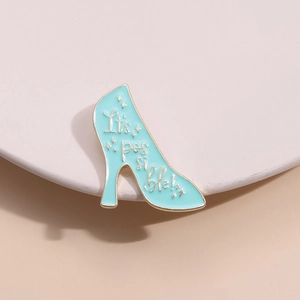 Elegant teal high heel enamel brooch with It’s possible! quote and gold details