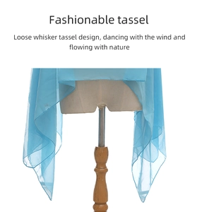 Detail of light blue sheer silk shawl with soft whisker tassels on a white background