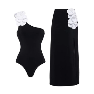 Detail of black one-shoulder swimwear with 3D white floral appliques and side slit skirt