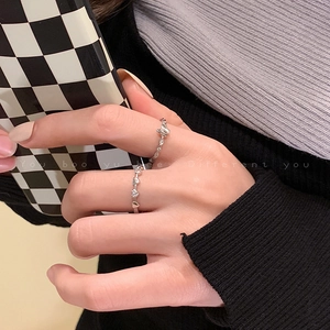 Close-up of silver butterfly and heart rings on hand with stylish knit background