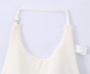 Detail of metal adjustment buckle and sewing on the cream halter neck top strap