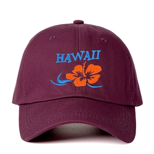 Close-up of Hawaii embroidery and orange hibiscus flower on purple cotton baseball cap