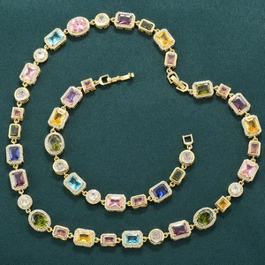 Luxury gold choker necklace set featuring colorful square gemstones on green velvet background