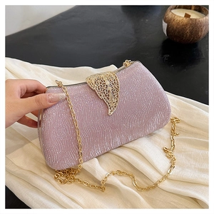 Detail of lavender sequin box clutch featuring ornate gold leaf clasp and chain strap
