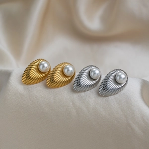 Close-up of elegant French vintage shell earrings with pearls in gold and silver plating