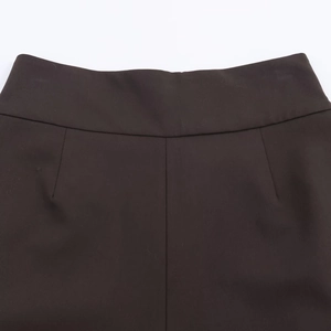 Gros plan détaillé du pantalon plissé marron foncé avec coutures de précision
