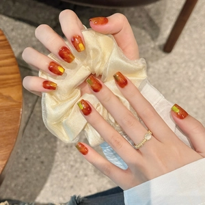 Maillard amber press-on nails with gold foil accents and elegant marble texture