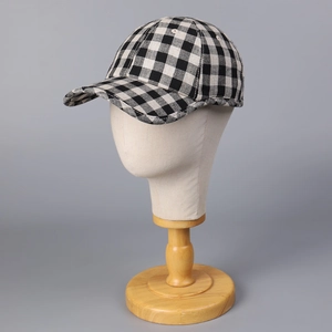 Classic black and white checkered linen baseball cap shown on a mannequin head stand