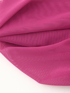 Detail of rose red mesh fabric texture with elegant draping and pleated net structure