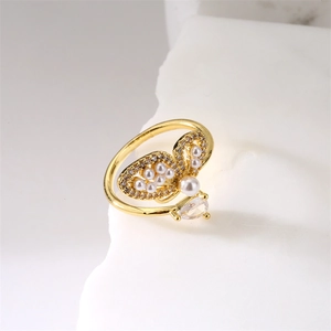 Vue détaillée bague papillon dorée avec perles et zircon sur socle en pierre