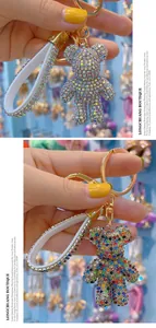 Close-up of sparkling rhinestone bear keychain with crystal-studded white leather strap