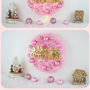 Detail of pink Christmas wreath featuring silver ornaments and Merry Christmas plaque