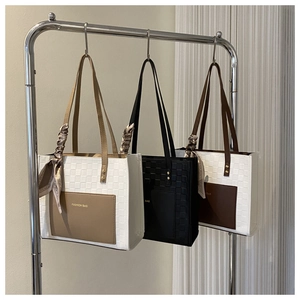 Detail of woven leather tote bags with silk scarves and printed fashion bag text