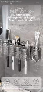 Detail of wall-mounted toothbrush holder with four grey ripple cups and toothpaste dispenser