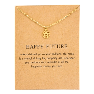 Detail of a gold star pendant necklace on a brown Happy Future gift card