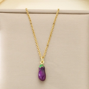 Vue détaillée d'un pendentif aubergine violet sur une chaîne dorée et tissu beige