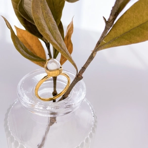 Détail d'une bague en titane plaqué or 18K ornée d'une perle blanche unique et brillante
