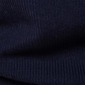 Detailed close-up of dark blue ribbed knit fabric showing high-quality cotton texture