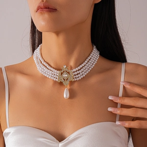 Detail of a multi-layer pearl choker with a crystal-encrusted gold filigree pendant
