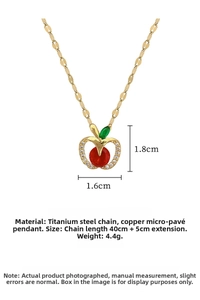 Detail of apple pendant necklace with red stone, white zircons, and gold titanium chain
